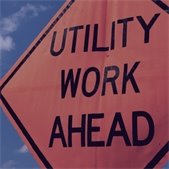 close up photo of Utility Work Ahead  orange construction sign