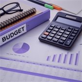 photo of binder with budget title and sheets with graphs and calculations