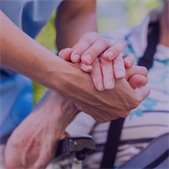 close up of elderly hand being held by a younger hand