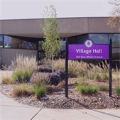 Village Hall with a purple sign that reads ‘Village Hall, 255 East Wilson Avenue