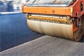 road construction machinery with roller paving black asphalt roadway