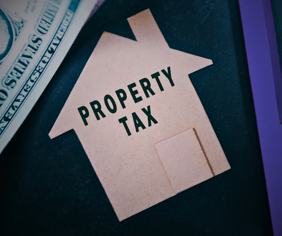 photo of small cardboard house cut-out and Property Tax text with dollar bill in background